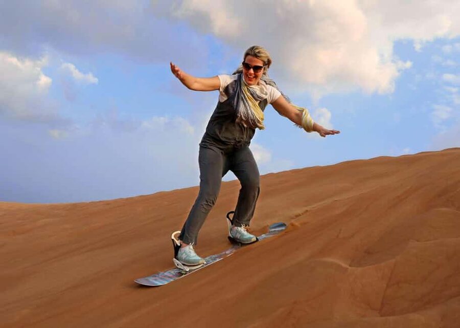 Desert Safari Dubai with Camel Ride, Sandboarding & Dinner - Sandboarding for a quick balance test