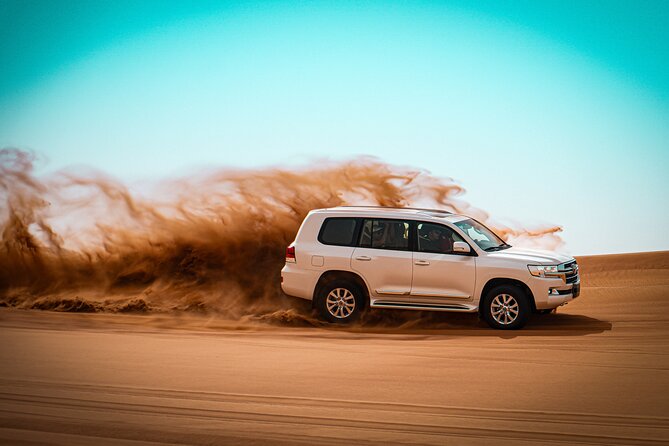 Dubai Morning Evening Desert Safari,Sand boarding and Camel ride - Sandboarding down a desert slope
