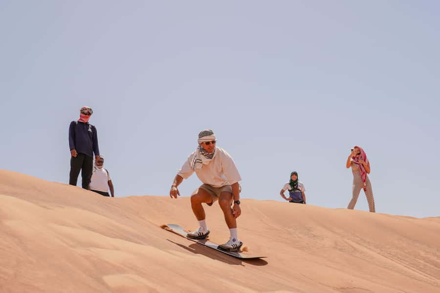Dubai: Red Dune Desert Safari, Quad Bike, Camels, and BBQ - Sandboarding on a steep red slope