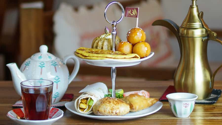 Dubai: Sunset Cruise on Traditional Boat & Emirati High Tea - A wooden abra beside modern Dubai